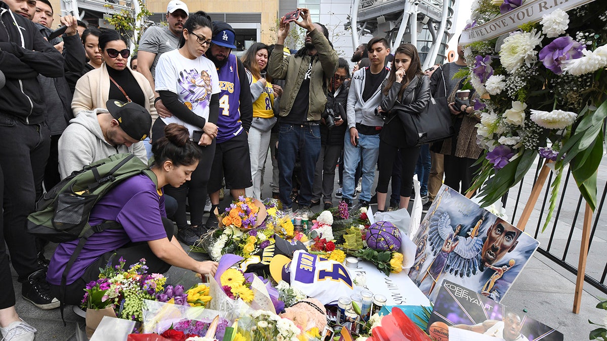 Valerie Samano, left, placing flowers at a memorial near the Staples Center after the death of Laker legend Kobe Bryant on Sunday. (AP Photo/Michael Owen Baker)