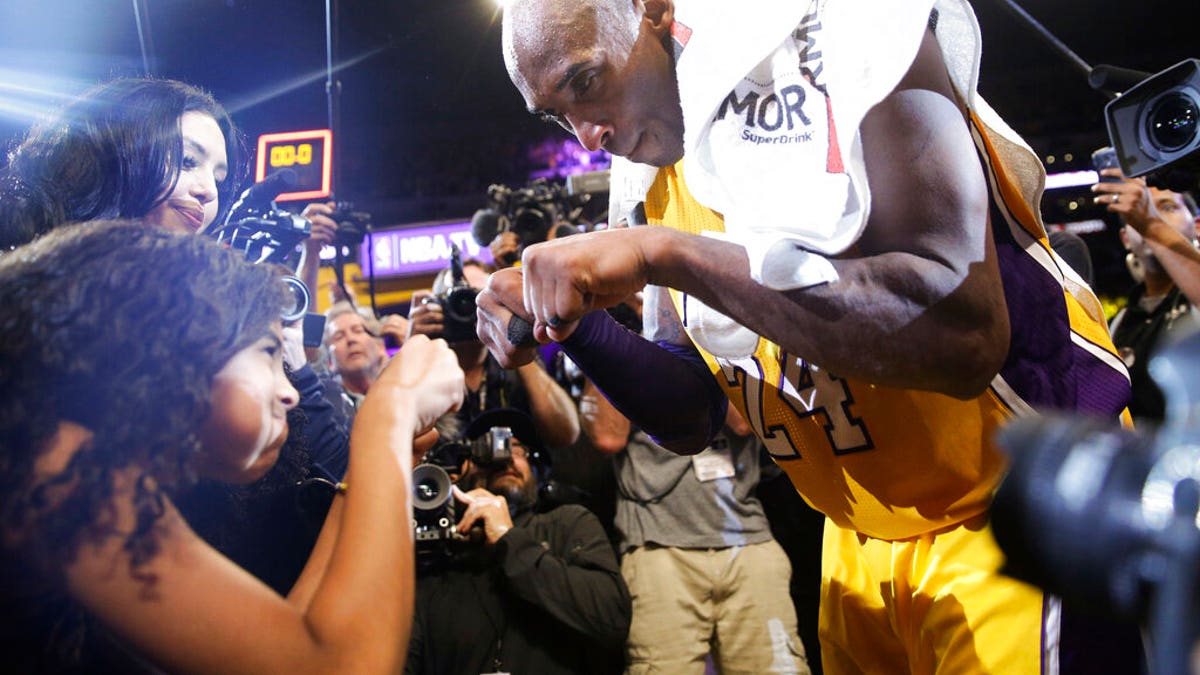 FILE - In this April 13, 2016 file photo Los Angeles Lakers' Kobe Bryant, right, fist-bumps his daughter Gianna after the last NBA basketball game of his career. (AP Photo/Jae C. Hong, file)