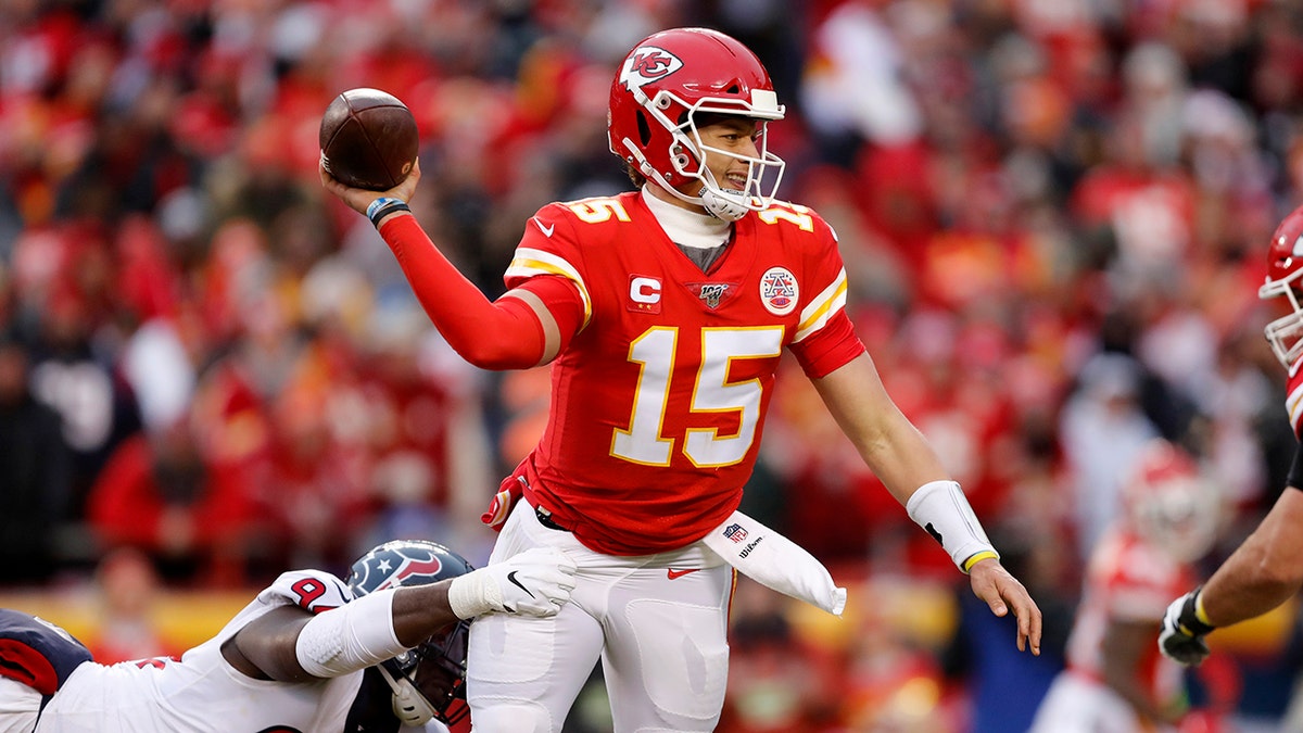 Kansas City Chiefs quarterback Patrick Mahomes (15) throws under pressure from Houston Texans defensive end Charles Omenihu (94) during the first half of an NFL divisional playoff football game, in Kansas City, Mo., Sunday. (AP Photo/Jeff Roberson)