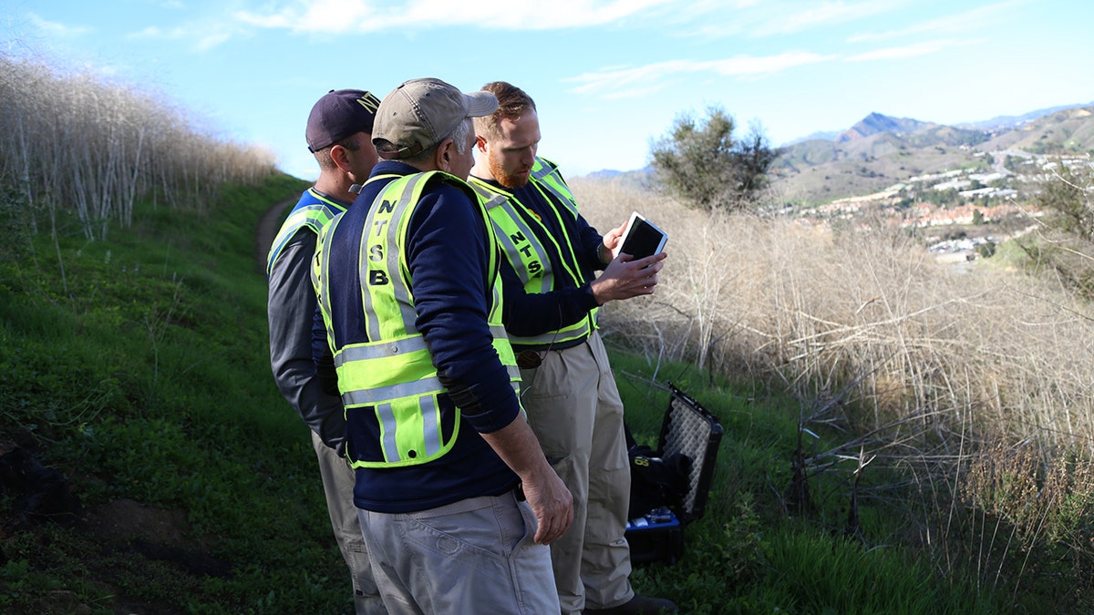 NTSB investigators reviewing coordinates to prepare a drone for mapping the site in Calabasas, Calif., where a helicopter crashed Sunday killing nine people, including Kobe Bryant and his 13-year-old daughter Gianna.