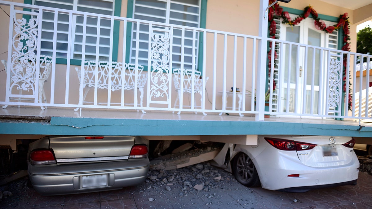 Cars were crushed under a home in Guanica that collapsed after Monday's earthquake. (AP Photo/Carlos Giusti)