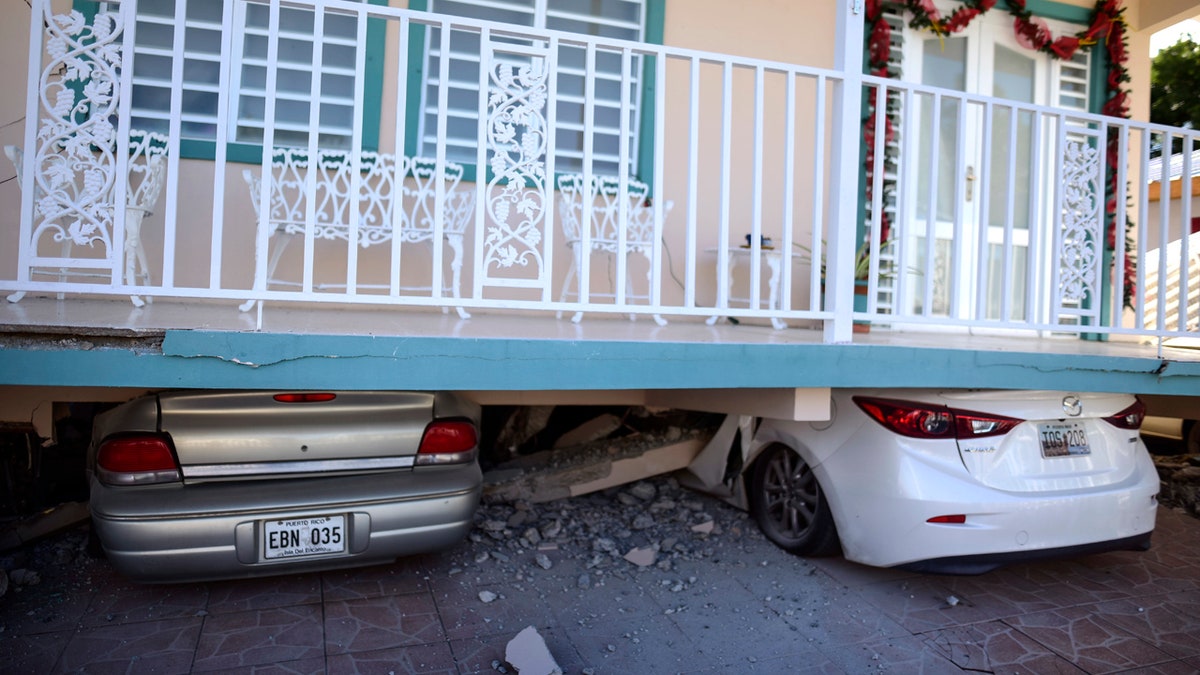 Cars are crushed under a home that collapsed after an earthquake hit Guanica, Puerto Rico, Monday, Jan. 6, 2020.