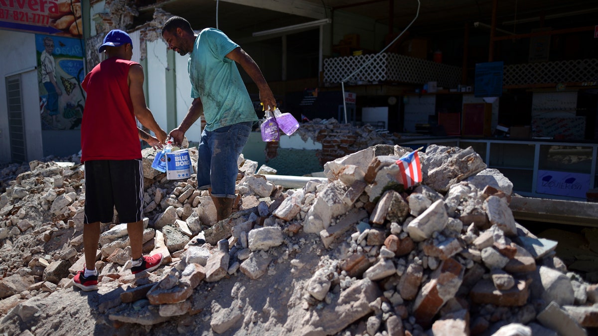 Store owners and family help remove supplies from Ely Mer Mar hardware store, which partially collapsed after an earthquake struck Guanica, Puerto Rico, Tuesday, Jan. 7, 2020.