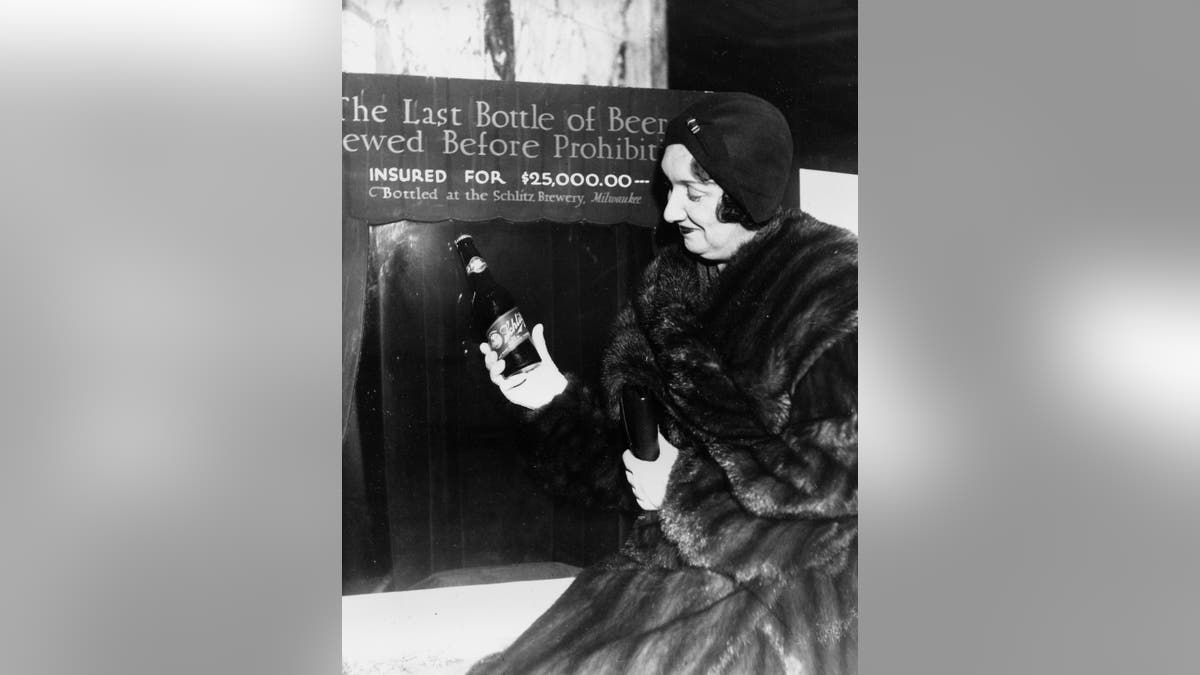 Rae Samuels holds the last bottle of beer that was distilled before prohibition went into effect in Chicago, Ill., Dec. 29, 1930. The bottle of Schlitz has been insured for $25,000. (AP Photo)