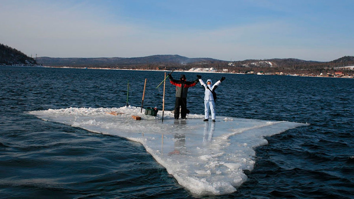 In this Tuesday, Jan. 28, 2020 photo released by the Russia Emergency Situations Ministry press service, showing two fishermen using a smaller piece of ice as a raft and try to row to the land.