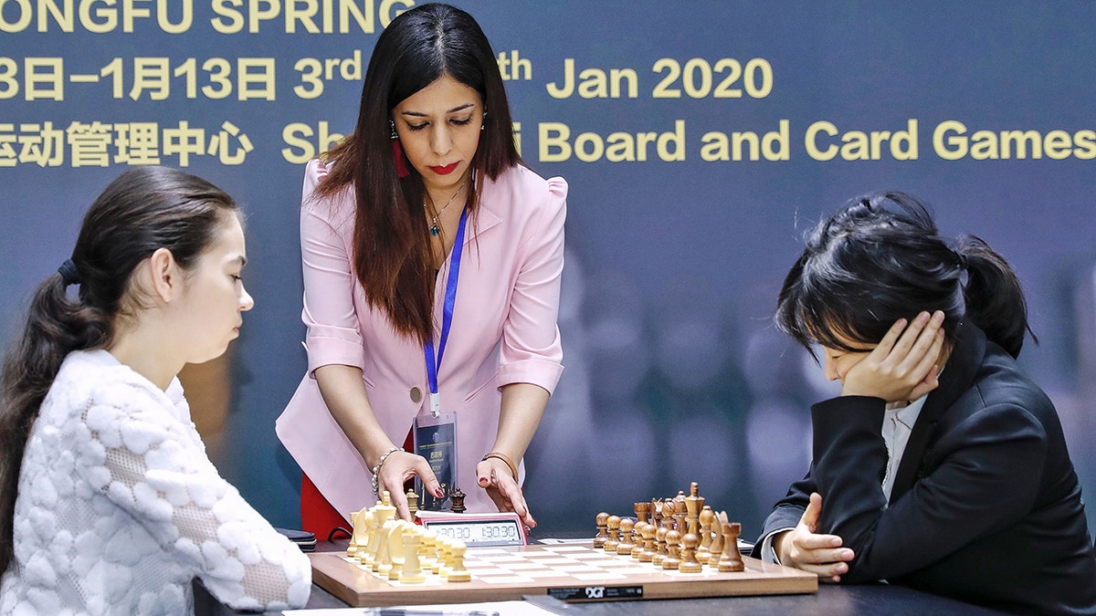 Shohreh Bayat (C), chief arbiter for the match between Aleksandra Goryachkina (front L) of Russia and Ju Wenjun (front R) of China, prepares for the match during the 2020 International Chess Federation (FIDE) Women's World Chess Championship in Shanghai on January 11, 2020. (Photo by STR/AFP via Getty Images)