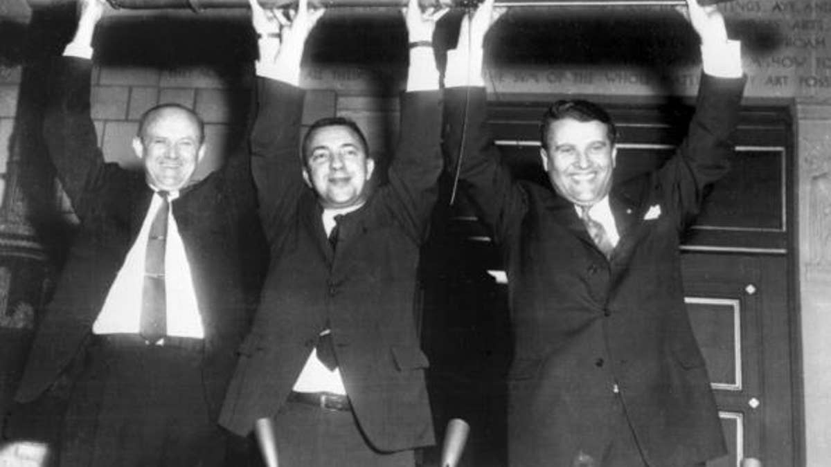 William Picketing, James Van Allen, and German scientist Wernher von Braun (from L to R) brandish a model of the first American satellite "Explorer 1", 31 January 1958 after the satellite was launched of by a "Jupiter C" rocket at Cap Canaveral Space Center. (Photo credit should read OFF/AFP/Getty Images)