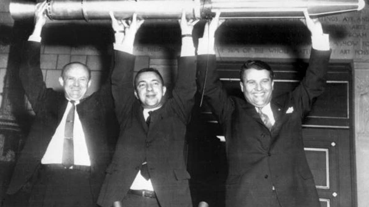 William Picketing, James Van Allen, and German scientist Wernher von Braun (from L to R) brandish a model of the first American satellite "Explorer 1", 31 January 1958 after the satellite was launched of by a "Jupiter C" rocket at Cap Canaveral Space Center. (Photo credit should read OFF/AFP/Getty Images)