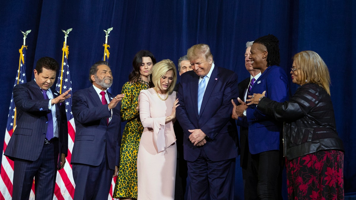 Faith leaders pray over President Donald Trump during an "Evangelicals for Trump Coalition Launch" at King Jesus International Ministry Friday in Miami. (Associated Press)