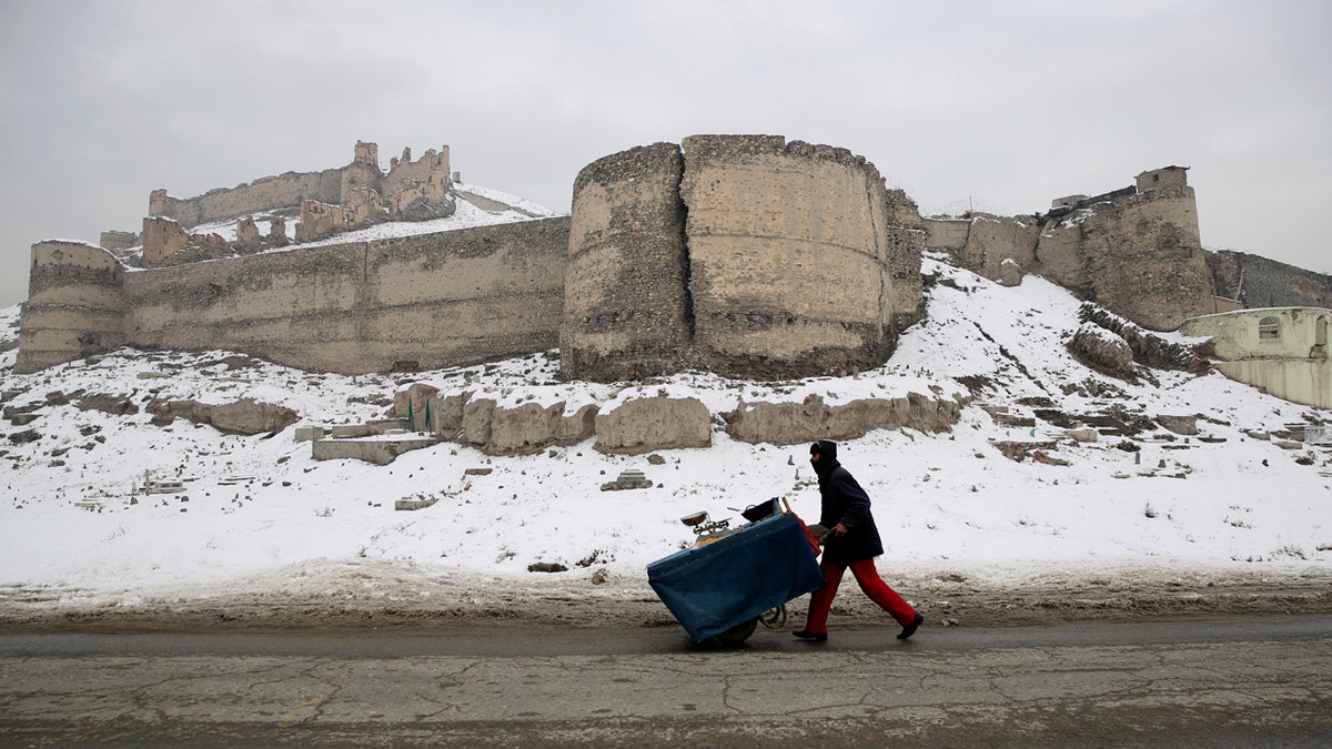 An Afghan street vendor pulls his hand cart after a heavy snowfall in Kabul, Afghanistan, Tuesday, Jan. 14, 2020.