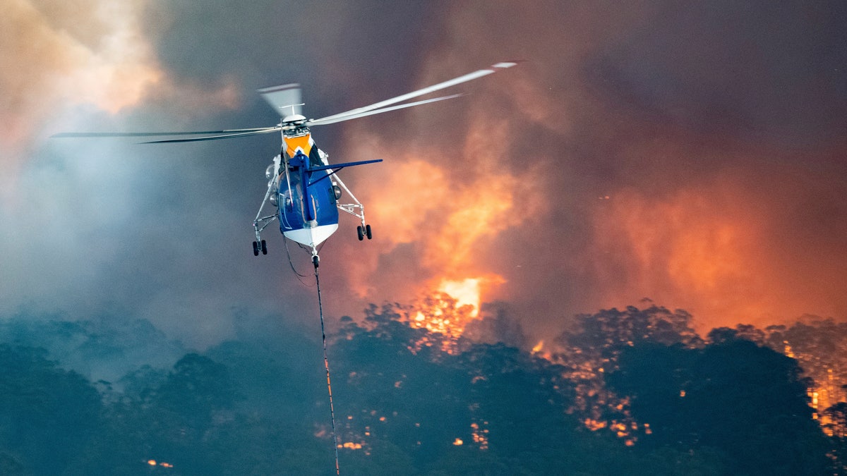 In this Monday, Dec. 30, 2019 photo provided by State Government of Victoria, a helicopter tackles a wildfire in East Gippsland, Victoria state, Australia.