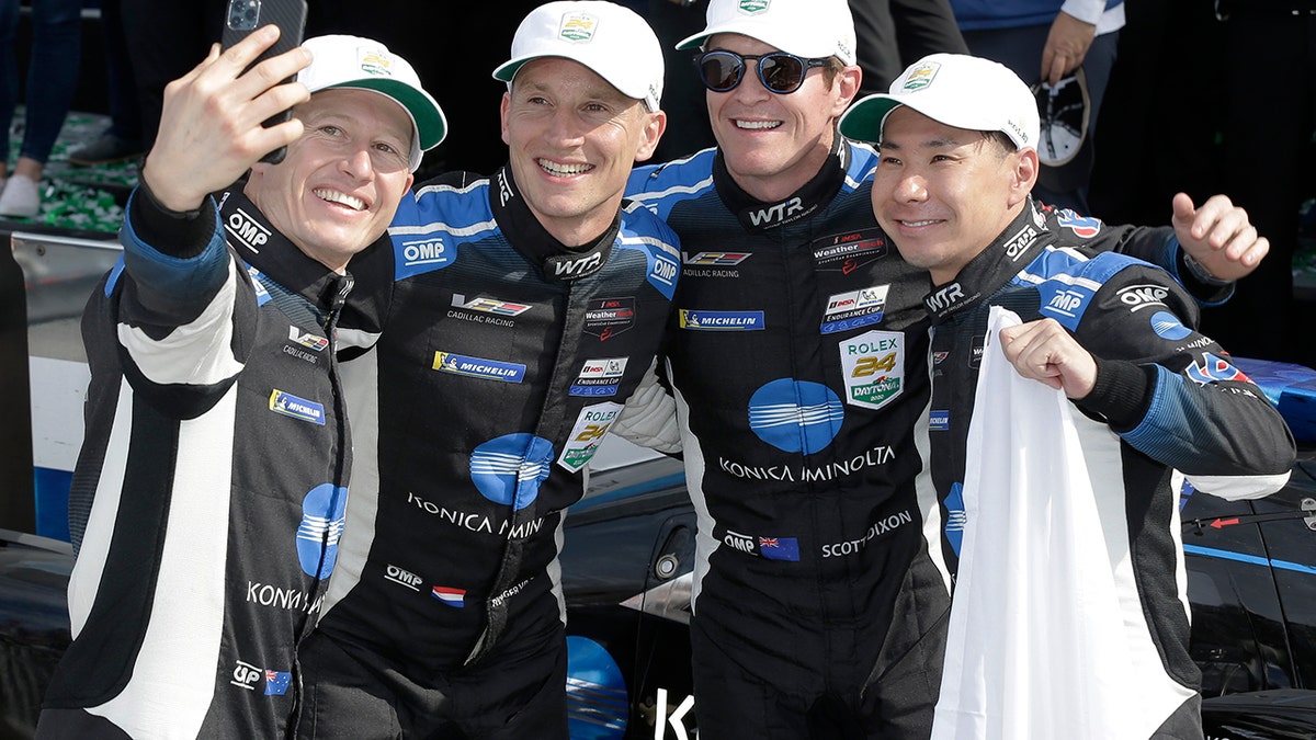 Drivers Ryan Briscoe, Renger van der Zande, Scott Dixon and Kamui Kobayashi celebrate after winning the Rolex 24 at Daytona.