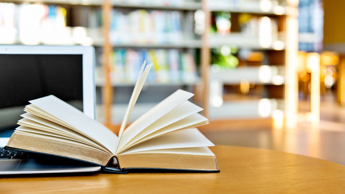 livro aberto em uma mesa de biblioteca