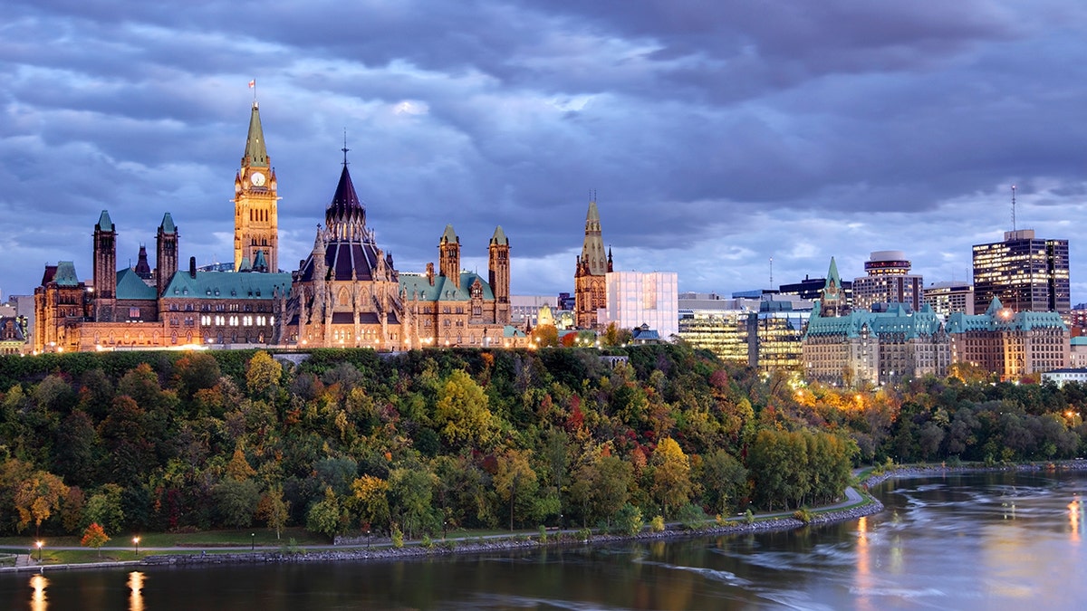 Parliament Hill atop a dramatic hill overlooking the Ottawa River in Ottawa, Ontario, in autumn