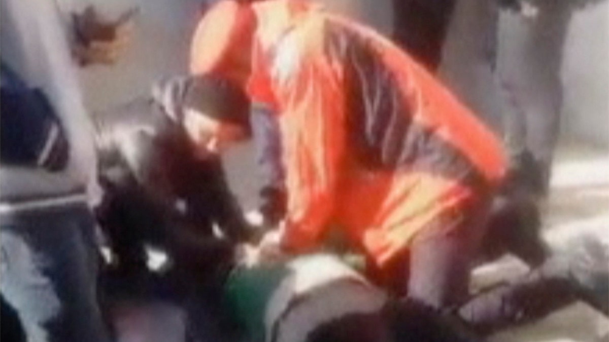In this frame grab from video posted online, people try to resuscitate victims of a deadly stampede at a funeral procession for Qassem Soleimani.