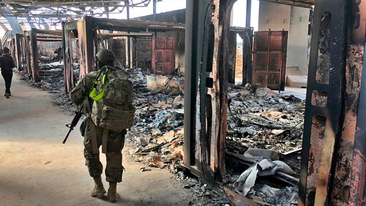 U.S. soldiers walk past damage at the Ain al-Asad base on Monday. (AP)
