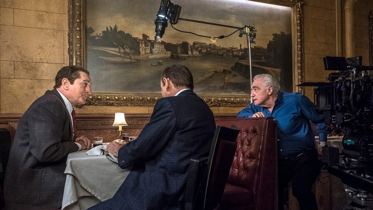 This image released by Netflix shows director Martin Scorsese, right, with actors Robert De Niro, left, and Joe Pesci on the set of "The Irishman." 
