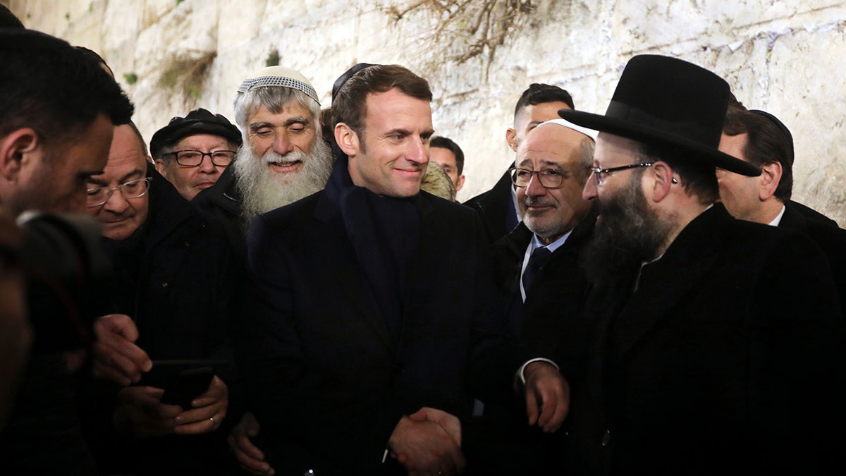 French President Emmanuel Macron, center, visits the Western wall, the holiest site where Jews can pray, in the Old City of Jerusalem, Wednesday, Jan. 22, 2020. Dozens of world leaders have descended upon Jerusalem for the largest-ever gathering focused on commemorating the Holocaust and combating modern-day anti-Semitism. (AP Photo/Mahmoud Illean)