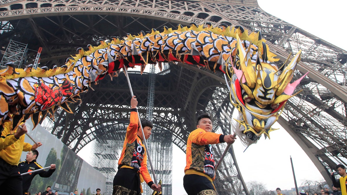 Members of the Chinese community dance with costumes to mark the Chinese New Year at the Eiffel Tower in Paris, Saturday Jan. 25, 2020.