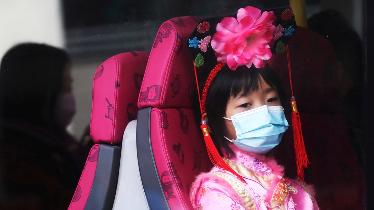 A girl wears a mask inside a bus in Hong Kong, Saturday, Jan. 25, 2020.
