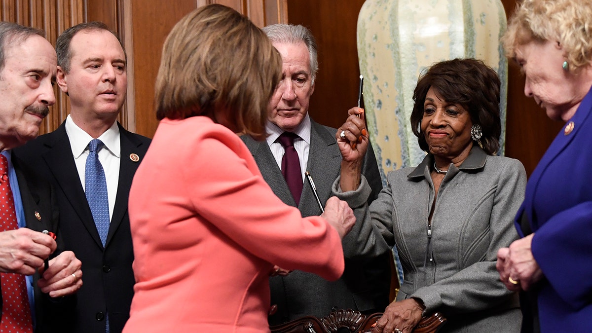 House Financial Services Committee Chairwoman Maxine Waters, D-Calif., second from right, reacts after getting a pen from House Speaker Nancy Pelosi of Calif., after she signed the resolution to transmit the two articles of impeachment against President Trump to the Senate for trial on Capitol Hill. (Associated Press)