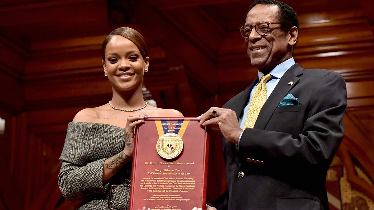 Rihanna receives the Harvard University Humanitarian of the Year Award from Dr. S. Allen Counter at Harvard University's Sanders Theatre on February 28, 2017 in Cambridge, Massachusetts.