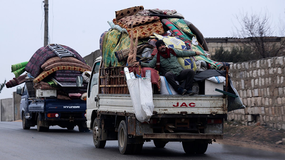 Syrians drive through the city of al-Mastouma, in Idlib province, as they flee a government offensive on Tuesday. (AP)