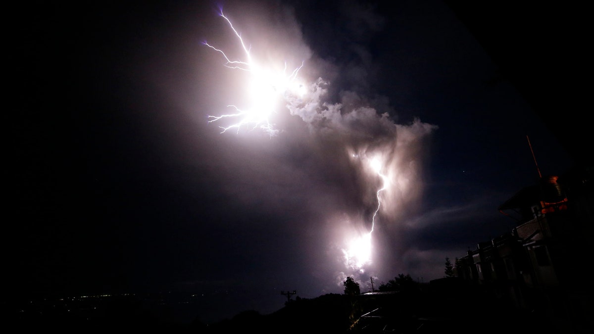 Lightning strikes beside the ash cloud as Taal Volcano erupts Sunday Jan. 12, 2020, in Tagaytay, Cavite province, outside Manila, Philippines.
