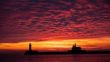The first sunrise of 2020 brings deep orange and pink colors over the Duluth Harbor North and South Breakwater Lighthouses in Duluth, Minn., Wednesday, Jan. 1, 2020. (Alex Kormann/Star Tribune via AP)