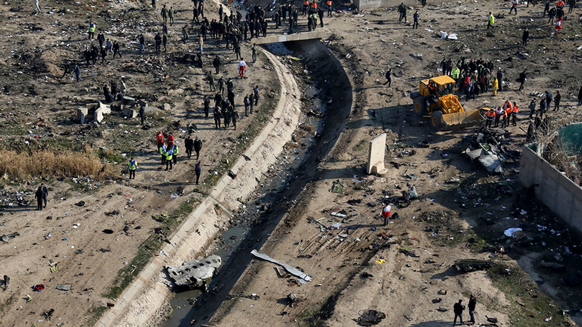 Rescue workers search the scene where an Ukrainian plane crashed in Shahedshahr, southwest of the Iranian capital of Tehran, on Wednesday. (AP)