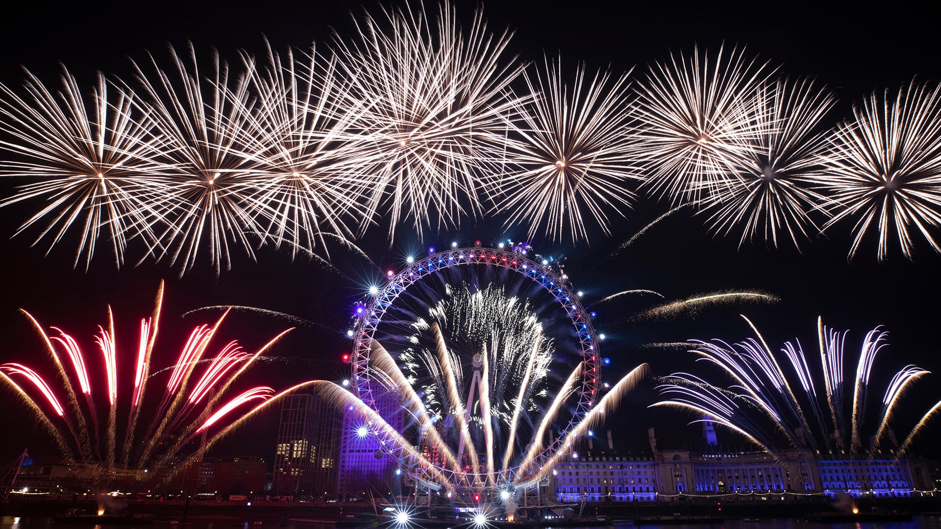 Fireworks marking the start of the new year explode over the London Eye Ferris wheel by the River Thames in London, Jan. 1, 2020.