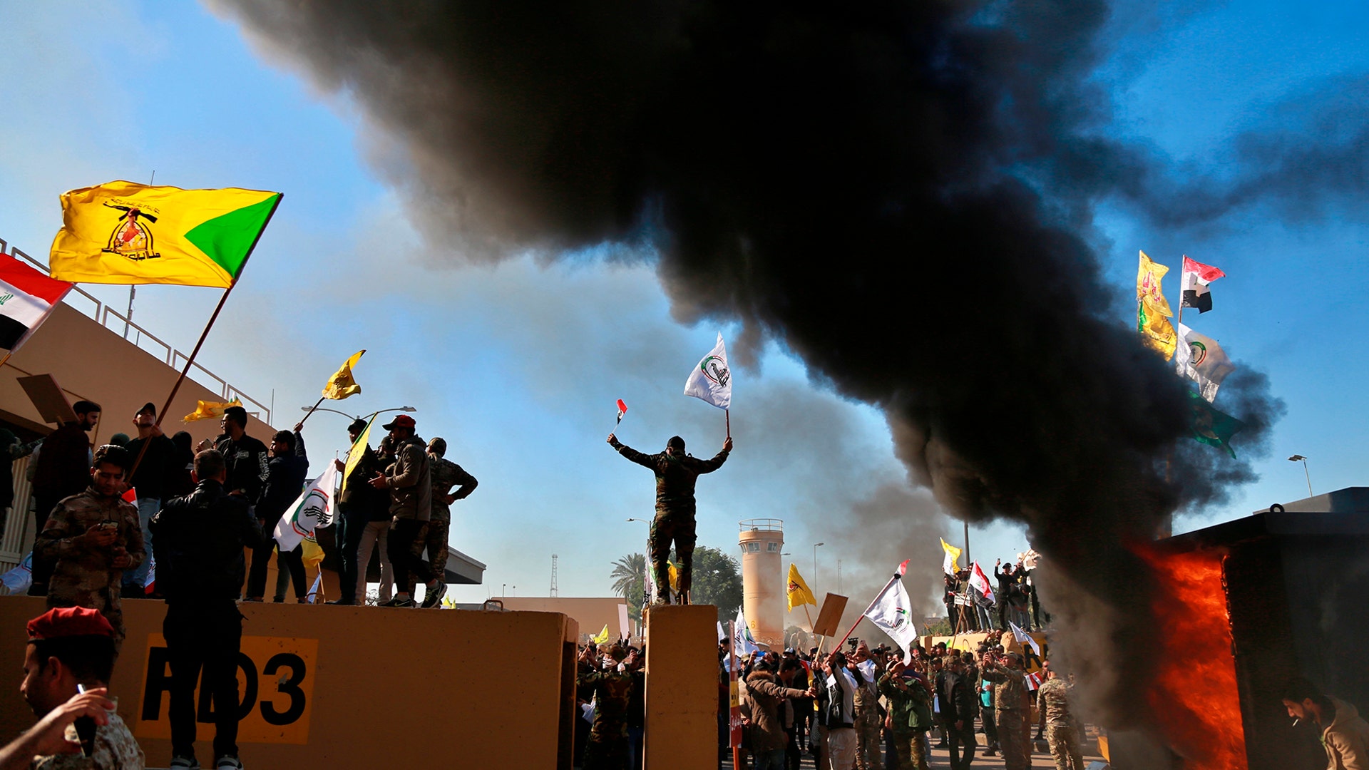 Protesters burn property in front of the U.S. embassy compound, in Baghdad, Iraq, Dec. 31, 2019.