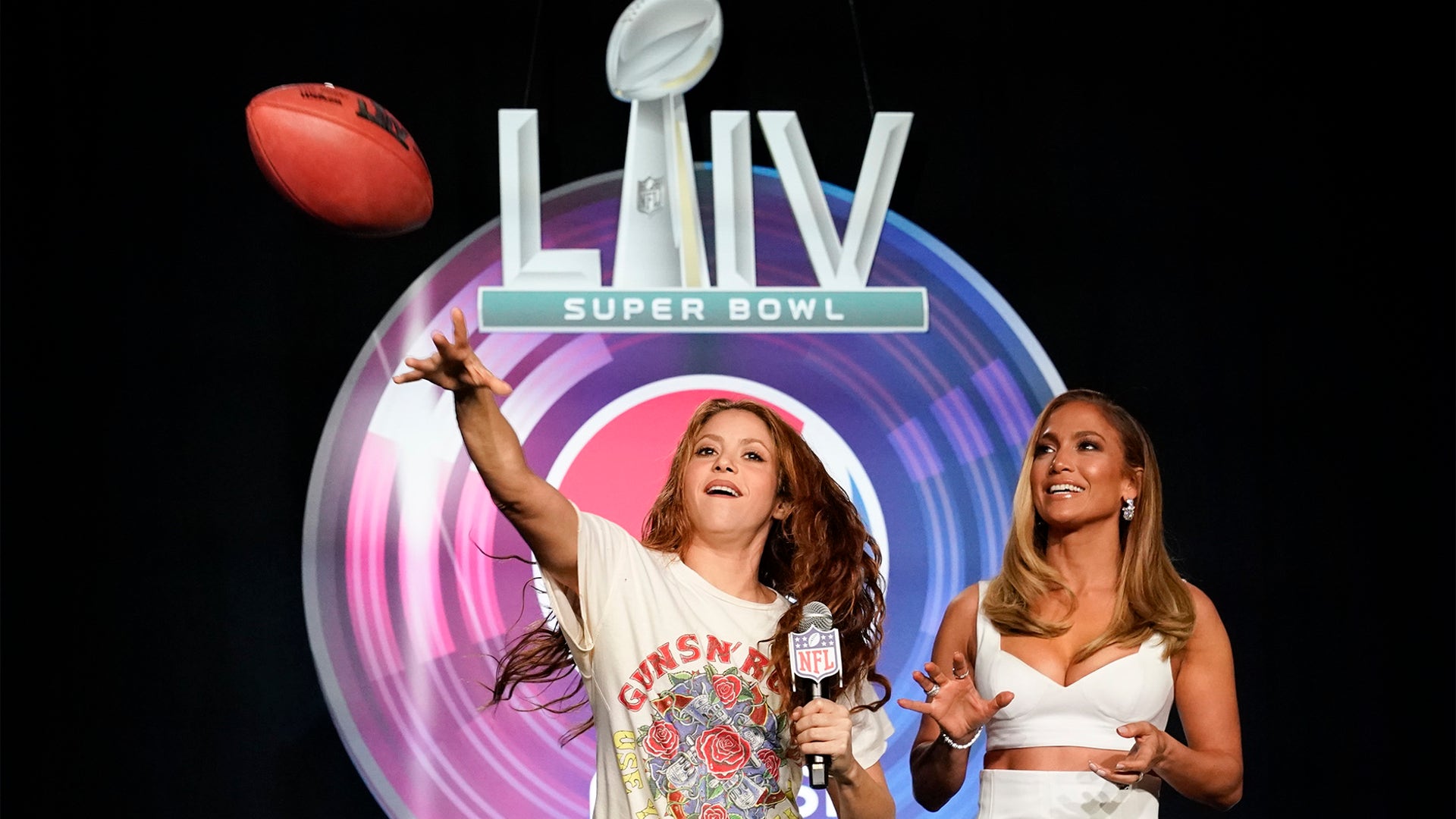 NFL Super Bowl 54 football game halftime performer Jennifer Lopez and Shakira throws a football at a news conference, Jan. 30, 2020, in Miami.