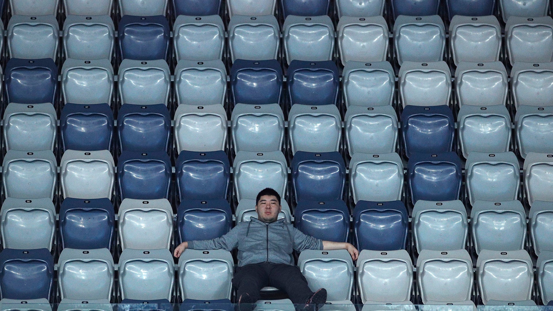A spectator watches the first-round match between Germany's Philipp Kohlschreiber and United States' Marcos Giron at the Australian Open tennis championship in Melbourne, Australia, Jan. 20, 2020.