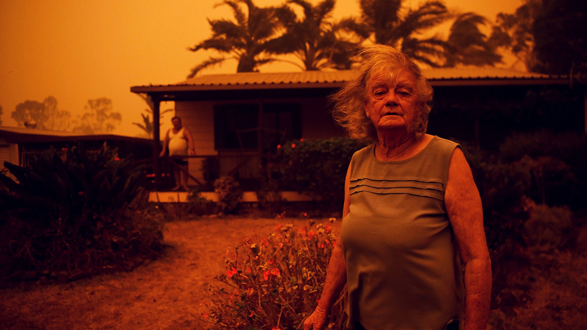 Nancy and Brian Allen stand outside their house as high winds push smoke and ash from the Currowan Fire towards Nowra, New South Wales, Jan 4, 2020.