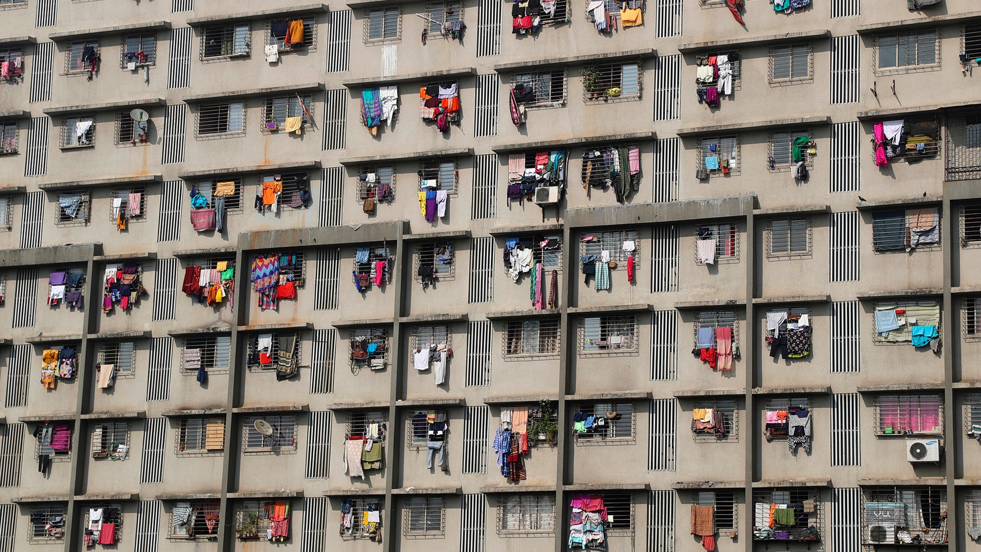 Clothes hang on windows to dry in a residential building in Mumbai, India, Jan. 20, 2020. 
