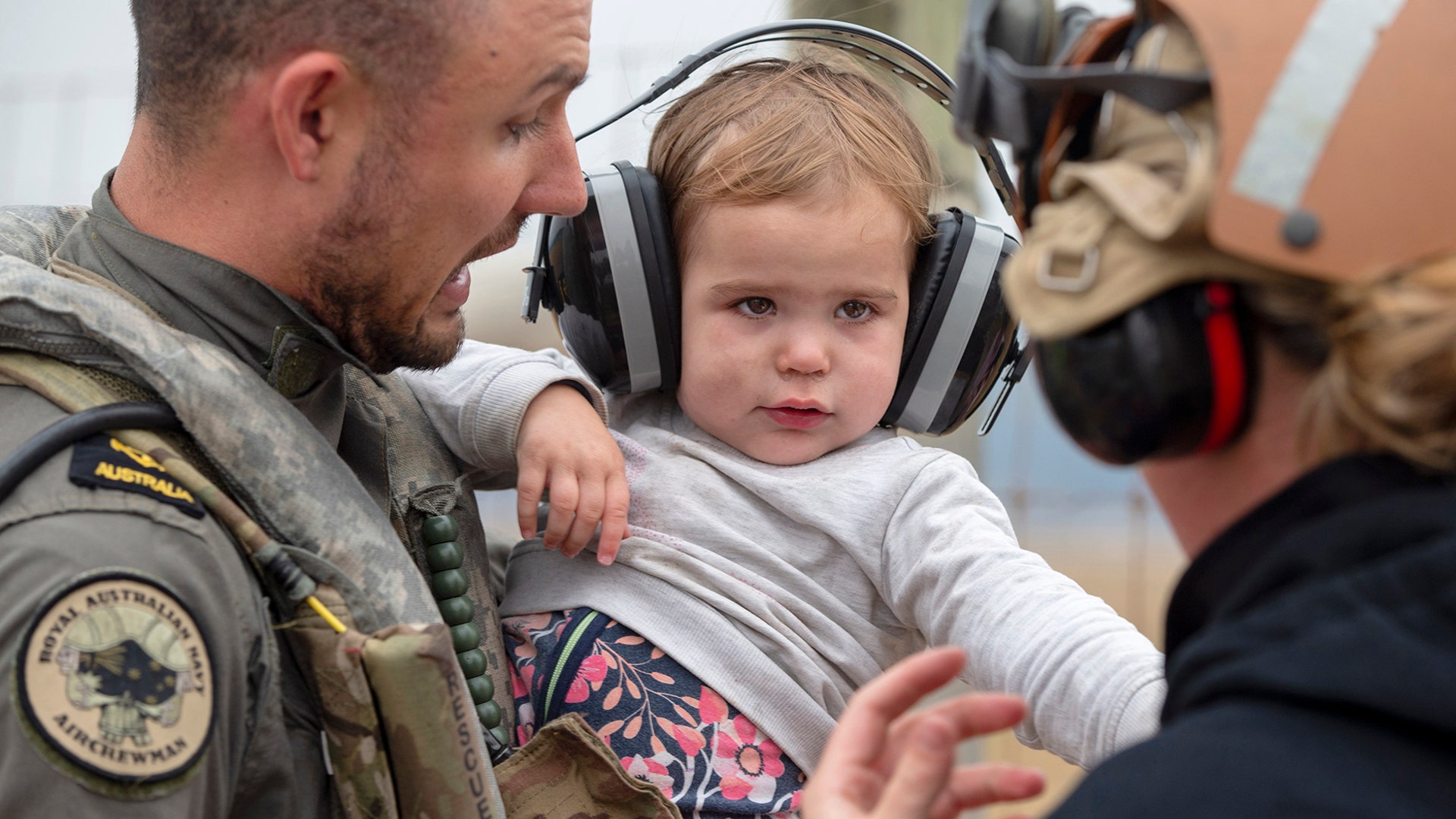 A child is helped onto a helicopter as the fire-ravaged community of Mallacoota is evacuated, Jan. 5, 2020.