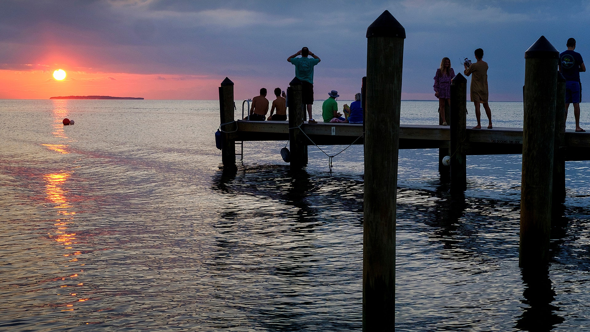 People line the pier in Key Largo, Florida, to watch the last sunset of the year, Dec. 31, 2019.
