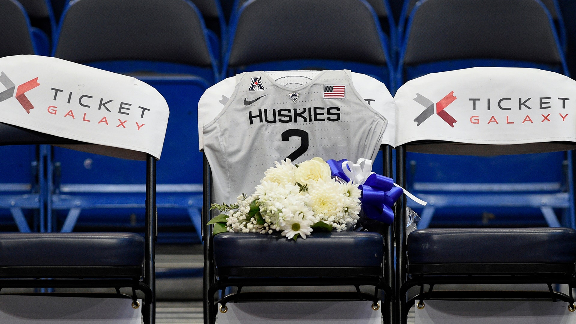 A seat with a jersey and flowers is reserved in memory of Gianna Bryant before an exhibition basketball game between the Connecticut Huskies and the US Women's National team, in Hartford, Jan. 27, 2020.