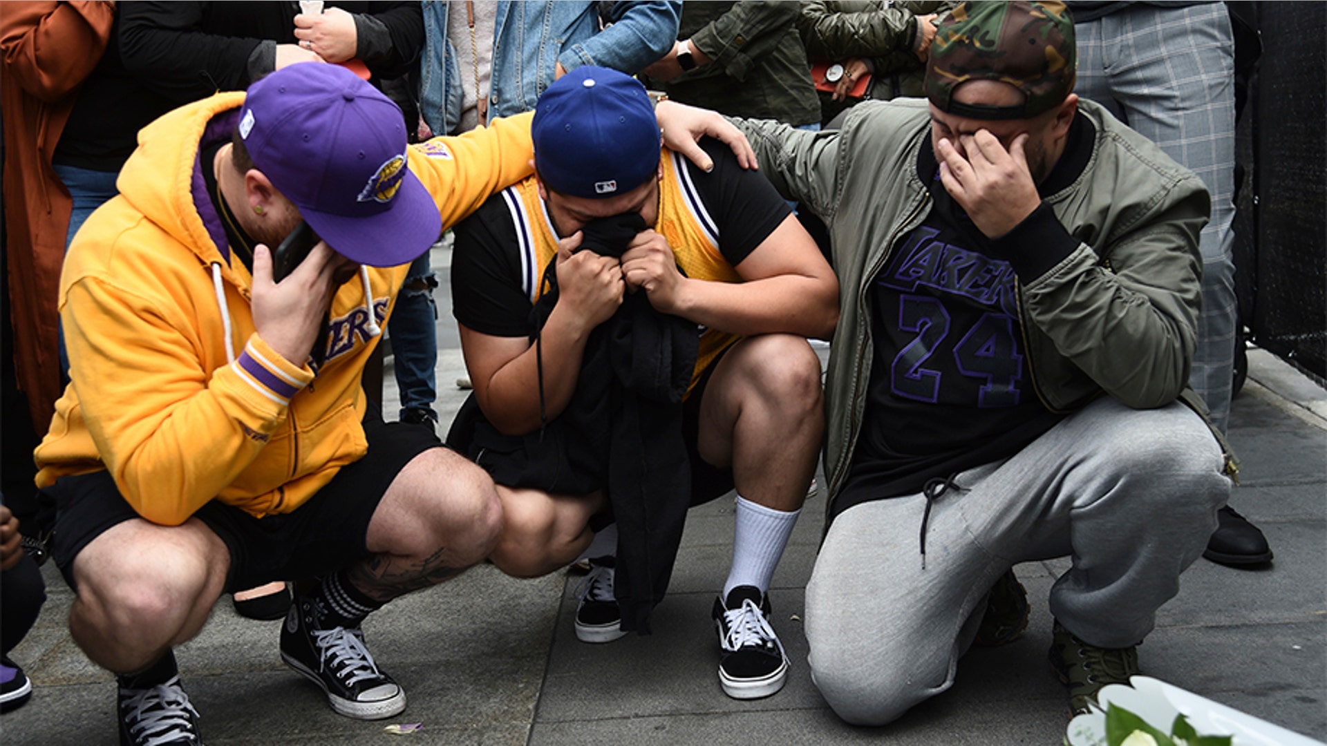 Los Angeles Laker fans Alex Fultz, from left, Eddy Rivas and Rene Alfaro mourn retired NBA star Kobe Bryant outside of the Staples Center prior to the 62nd annual Grammy Awards.