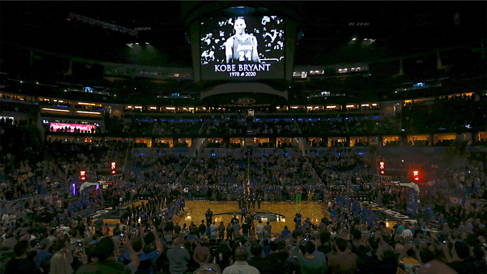 Fans stand for a moment of silence honoring Kobe Bryant before a game between the Orlando Magic and the LA Clippers.