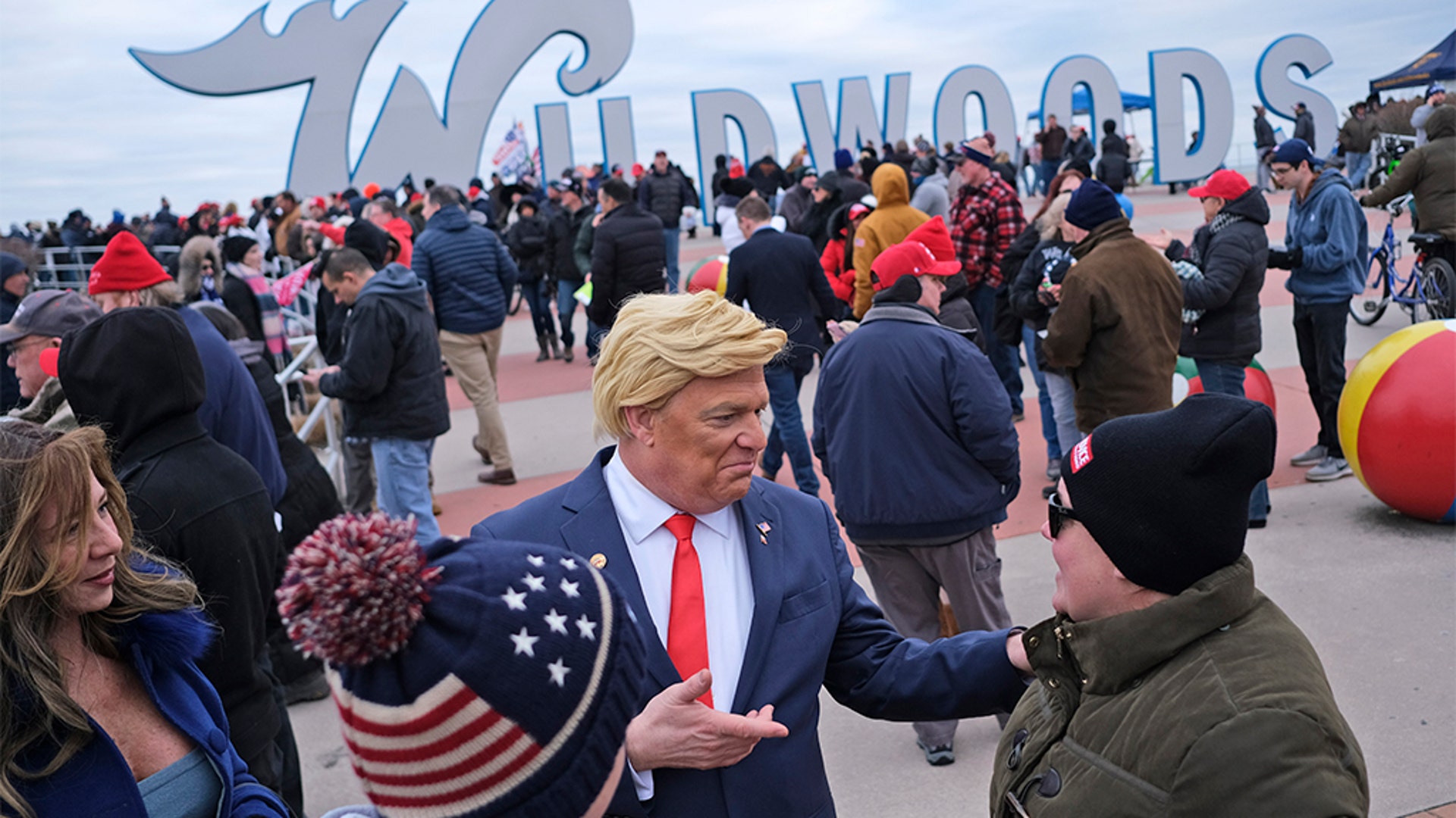 Tim Carney, dressed as President Trump, talking with people near the boardwalk before the start of the campaign rally.