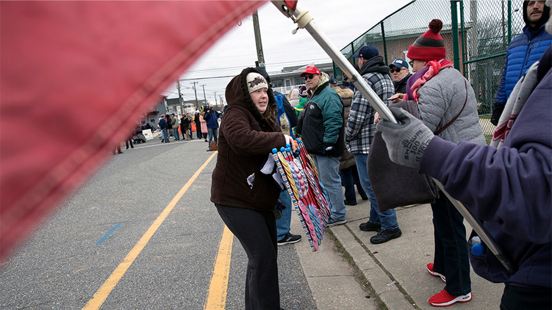 A woman selling buttons to people standing in line near the Wildwoods Convention Center.