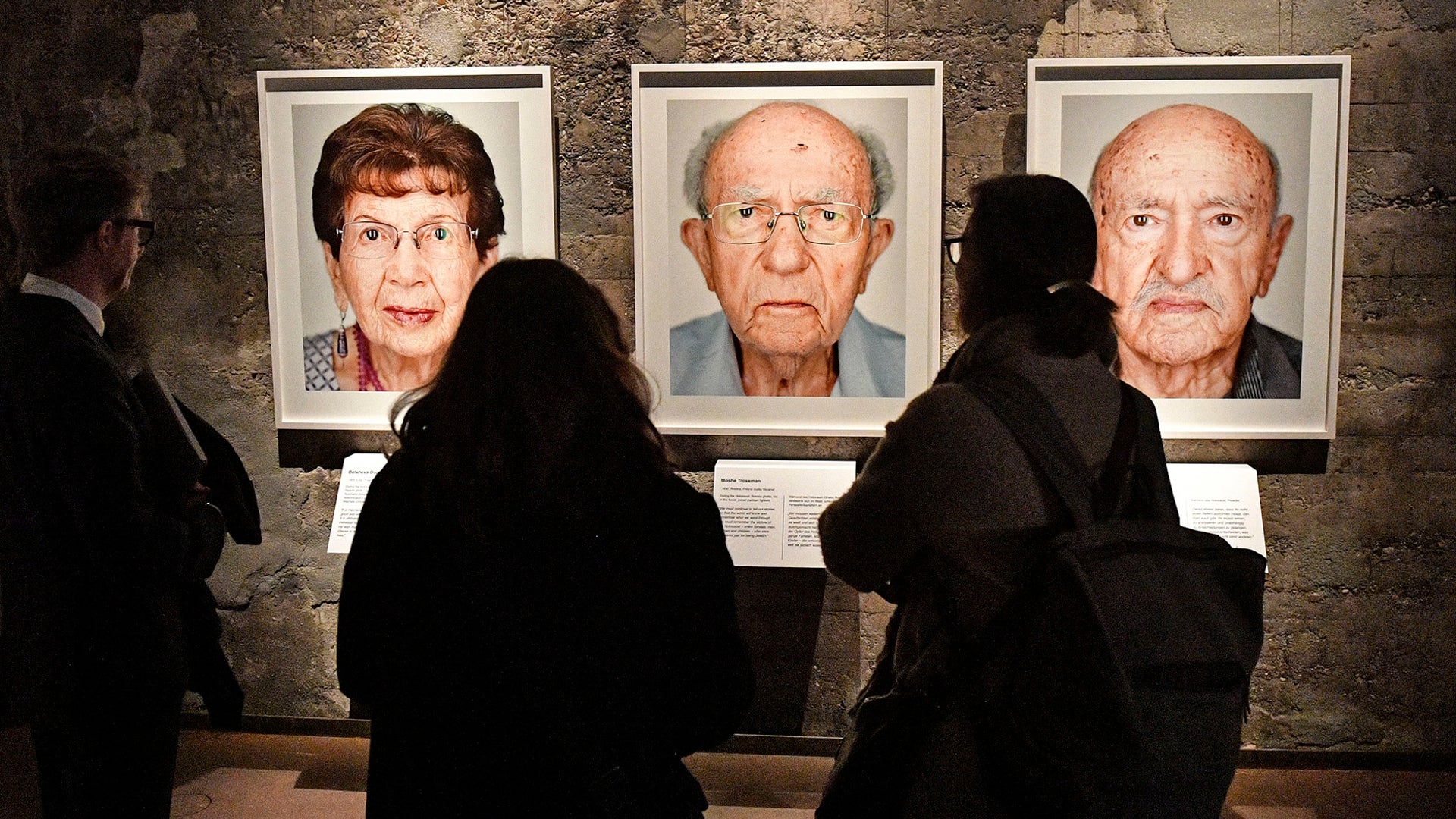 Visitors look at portrait photos of the exhibition "Survivors - Faces of Life after the Holocaust" at the former coal mine Zollverein in Essen, Germany, on Jan. 21, 2020. 