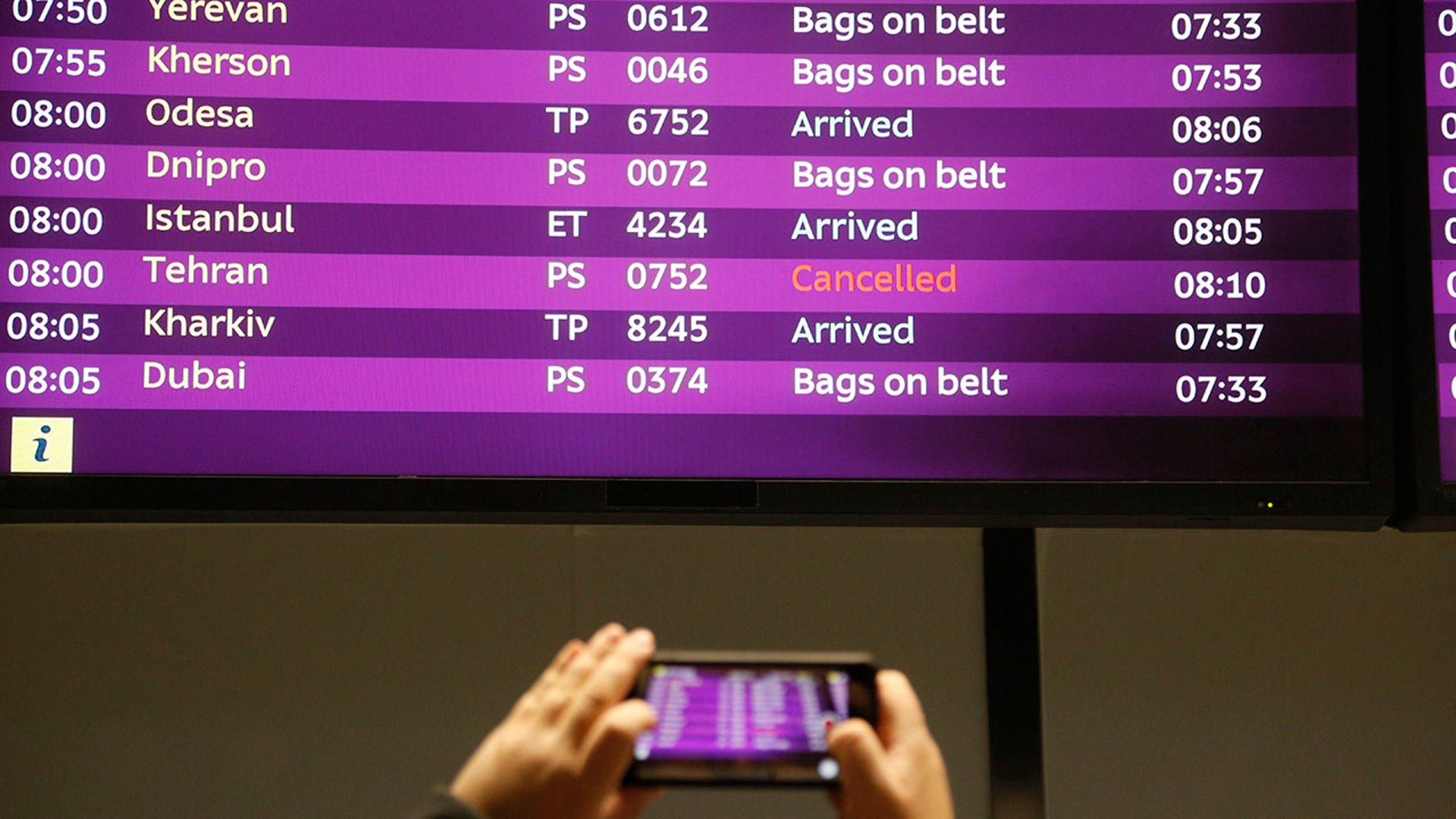A man at Borispil international airport outside Kiev takes a photo of the arrivals board with the cancelled flight from Tehran after the Ukrainian 737-800 plane crashed on the outskirts of Tehran. 