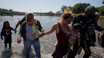 Caravan migrants cross Mexico river, throw rocks at country's national guard in response to tear gas