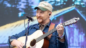 Country music singer Tyler Childers helps ground crew clean up after his concert