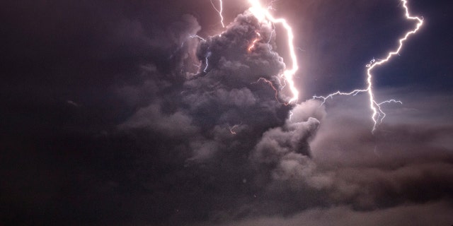 Lightning strikes as a column of ash surrounds the crater of Taal Volcano as it erupts on Jan.12, 2020 as seen from Tagaytay city, Cavite province, Philippines.