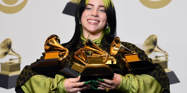 Billie Eilish poses in the press room with the awards for best album and best pop vocal album for "We All Fall Asleep, Where Do We Go?", best song and record for "Bad Guy" and best new artist at the 62nd annual Grammy Awards at the Staples Center on Sunday, Jan. 26, 2020, in Los Angeles.
