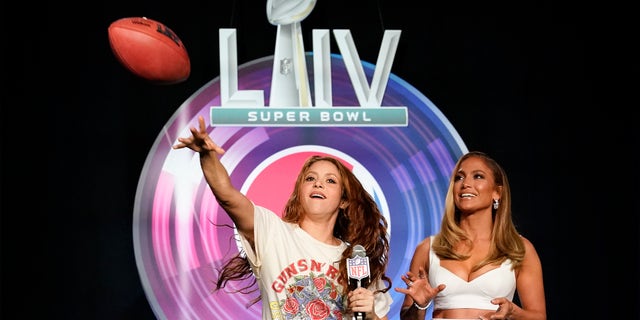 Shakira throws a football at a news conference Thursday alongside J. Lo.